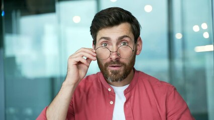 portrait of surprised businessman looking at camera computer monitor screen. surprised by the good news wow emotion shocked shoots glasses surprise amazement wonder astonishment worker entrepreneur