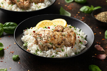 Grilled Chicken thighs served with rice in a black bowl