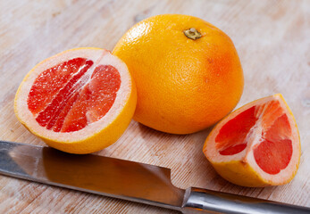 Whole and half fresh yellow pomelo on wooden table. Healthy vegetarian ingredient