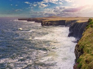 Obraz premium Beautiful scenery of Kilkee cliffs in county Clare, Ireland. Stunning Irish nature landscape. Day time, dramatic sky with clouds. Popular tourist and travel area with amazing view. Nature scene.