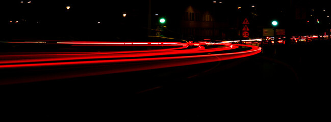 Lights of cars at night. Street line lights. Night highway city. Long exposure photograph night road. Colored bands of red light trails on the road. Background wallpaper defocused blurred