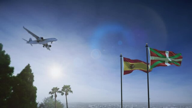 Airplane landing in Basque Province, Spain. A generic passenger plane lowering its landing gears approaching an airport near in Barcelona. Spanish flag waving along with Basque flag.
