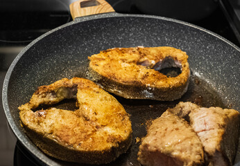 Fish fillet fried in the pan. Home cooking fish fillet on a stove top.