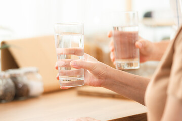 Family health care in house concept, Asian senior elderly couple drink a glass of water in kitchen...