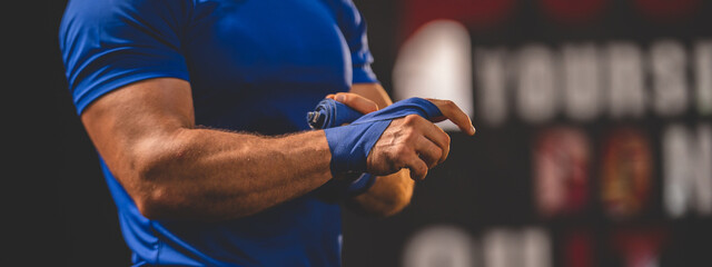 Closeup of hands of young male athlete trainer determined to workout for a healthy lifestyle tying...