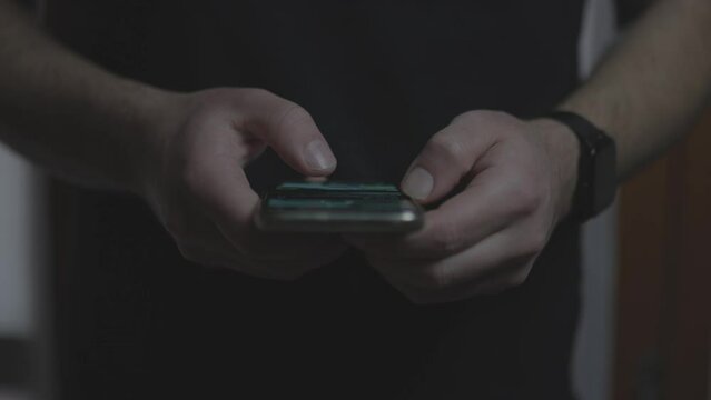 Doom scrolling. Hands of bored man scrolls page app on mobile phone. Browsing internet or social network. Compulsive scrolling concept. Front view