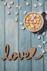 Wooden word love with heart romance with white coffee cup of hot chocolate and small marshmallows. Minimal concept of greeting card for Valentine's Day, Mother's Day, Women's Day Festive holiday card