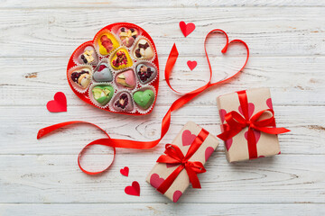Valentine day composition: sweet candy, with gift boxes with bow and red felt hearts, photo template, background. Top View with copy space