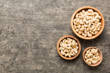 cashew nuts in wooden bowl on table background. top view. Space for text Healthy food