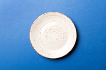 Top view of isolated of colored background empty round beige plate for food. Empty dish with space for your design