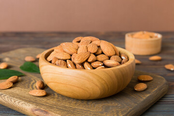 Fresh healthy Almond in bowl on colored table background. Top view