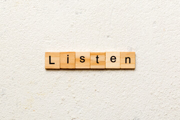 listen word written on wood block. listen text on table, concept