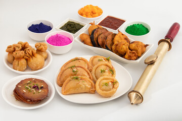 Variety Of Traditional Holi Mithai And Fritters viz. Indian Sweet Dumplings Gujiya, Chandrakala, Malpua, Kalash Gujia, Pua, Potli Karanji, Begun Bhaja, Baingan Tawa Fry, Pakoda With Gulal And Pichkari