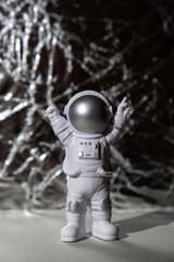 Plastic toy figure astronaut on silver background Copy space. Concept of out of earth travel,...