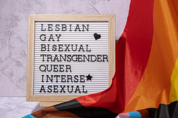 LGBTQIA description frame on Rainbow LGBTQIA flag made from silk material. LESBIAN, GAY, BISEXUAL,...