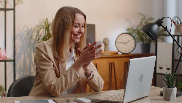 Sneaky cunning blonde young businesswoman with tricky face gesticulating and scheming evil plan, thinking over devious villain idea, cunning cheats, jokes and pranks at office workplace with laptop