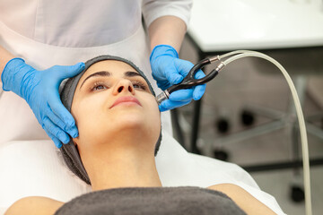 facial skin vacuum cleaning procedure. female patient lies in a cosmetology clinic on a facial skin...