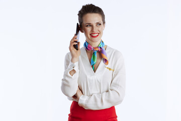 happy stylish air hostess woman on white using smartphone
