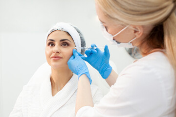 mesotherapy procedure in cosmetology clinic, dermatologist doctor makes injection into the patient's with syringe