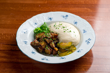 Salad with baked aubergines and pickled cucumbers on wooden table