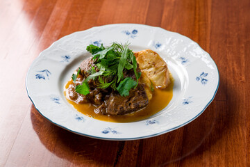 Beef cheeks with mashed potatoes on wooden table