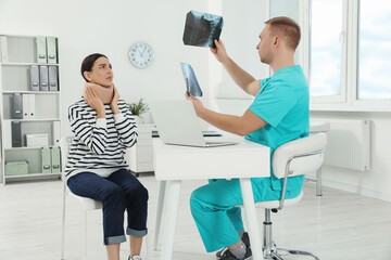 Doctor with neck MRI images consulting patient in clinic