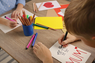 Children making beautiful greeting cards at table indoors, closeup