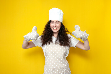 cute young girl cook in apron and baking gloves shows like on yellow isolated background, woman...