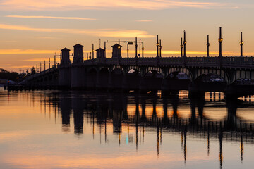 The 1927 double-leaf bascule Bridge of Lions connecting downtown to Anastasia Island across Matanzas Bay seen in silhouette at sunset, St. Augustine, Florida, USA