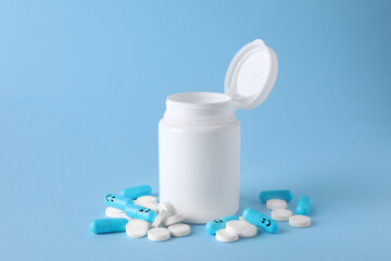 Antidepressants with happy emoticons and medical jar on light blue background