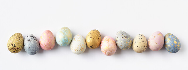 Banner with colorful spotted Easter eggs in row. White Easter background or greeting card. Copy space.
