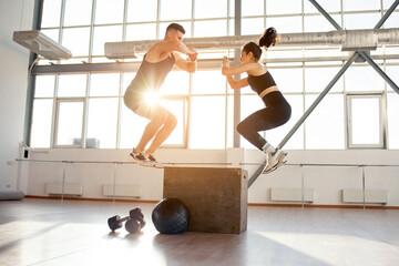 athletic couple in sportswear at crossfit training in the fitness room, woman and man together at...