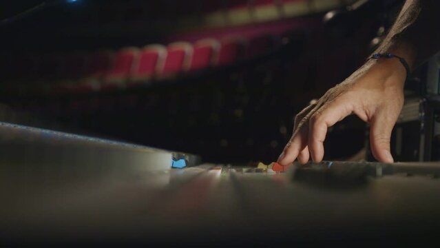 sound engineer fingers on audio mixing console fader in recording, broadcasting studio