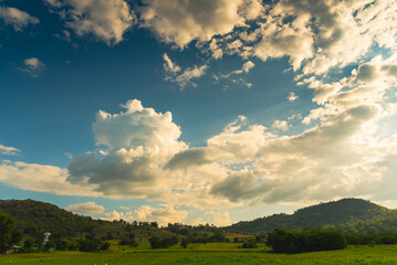Dramatic sunset over mountain landscape. Beautiful landscape foggy hills twilight time. Blue golden sky sunrise dramatic beautiful landscape mountain. Dawn sky gold dusk time cloudscape with sunlight