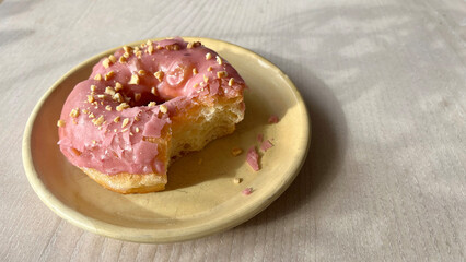 Strawberry donut on the plate at cafe