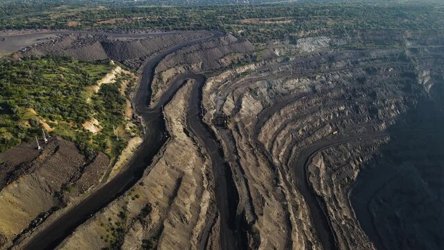 Panorama aerial view shot open pit mine coal mining, dumpers, quarrying extractive industry stripping work. Big Yellow Mining Trucks. View from drone at opencast mining with lots of machinery trucks