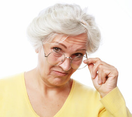 An elderly woman looks skeptically over her glasses.