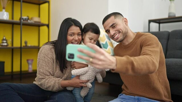 Couple and son having video call sitting on floor at home