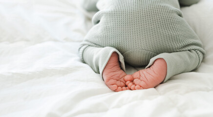 Cute feet of newborn baby sleeping on stomach on white blanket.Close-up shot .Copy space for text.