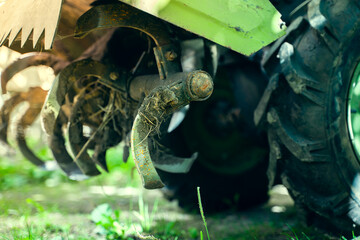 Rototiller of a walk-behind tractor close-up. Agricultural machinery for processing and care of the...