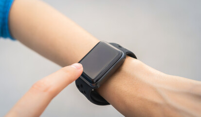 Woman wearing a smartwatch and touching to check on o'clock.