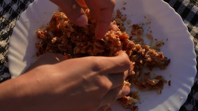Mixing dessert ingredients with hands in the sunset on a plate