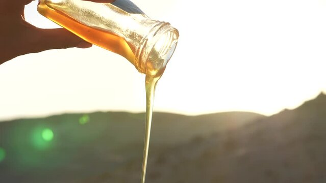 Pouring honey onto a plate in the desert sunset