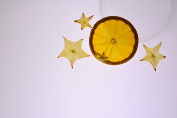 Rodaja de naranja y fruta estrella amarilla en fondo blanco,  fruta ,cítrico ,naranja ,rodaja...