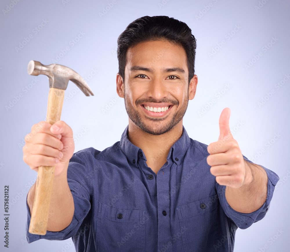 Sticker Man, studio and portrait with thumbs up and hammer for handyman, maintenance or repair work with smile. Happy asian model person on purple background for engineer, mechanic or technician job tools