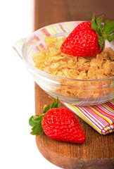 Yogurt bowl with fresh sliced strawberries and dry corn flakes. Traditional corn flakes breakfast concept. Healthy eating concept. Food and health