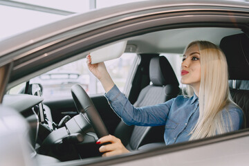 Stylish and elegant woman in a car salon