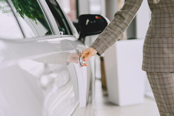 Stylish and elegant woman in a car salon