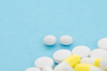 Heap of various pills on blue background