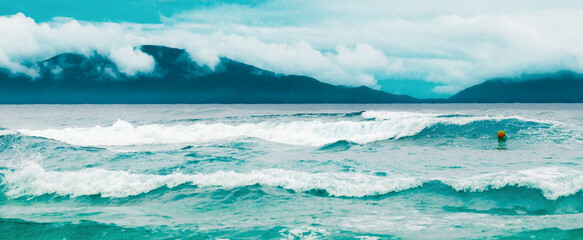 Breaking blue waves and an overcast sky.